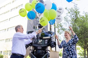 Die Regierende Bürgermeisterin Franziska Giffey und Prof. Dr. Ulrich Panne übernehmen vom Roboter Nox einen Strauss Luftballons.