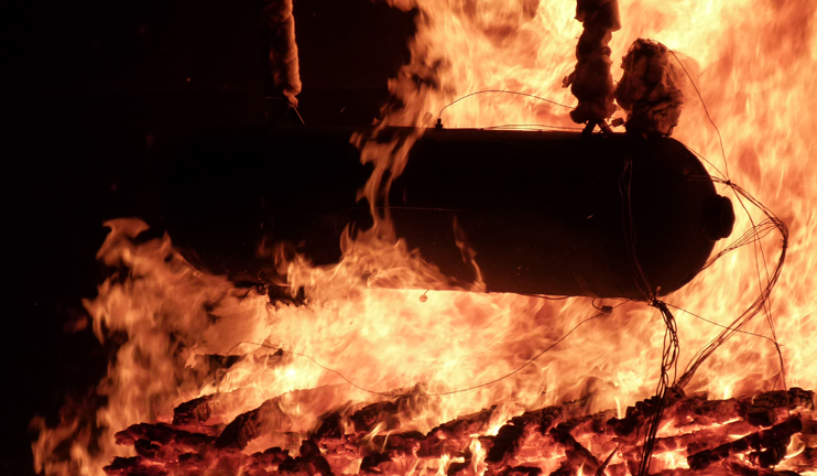 Ein Feuer brennt unter einem Gasbehälter, der mit Sensoren verdrahtet ist. Ein Feuer brennt unter einem Gasbehälter, der mit Sensoren verdrahtet ist.