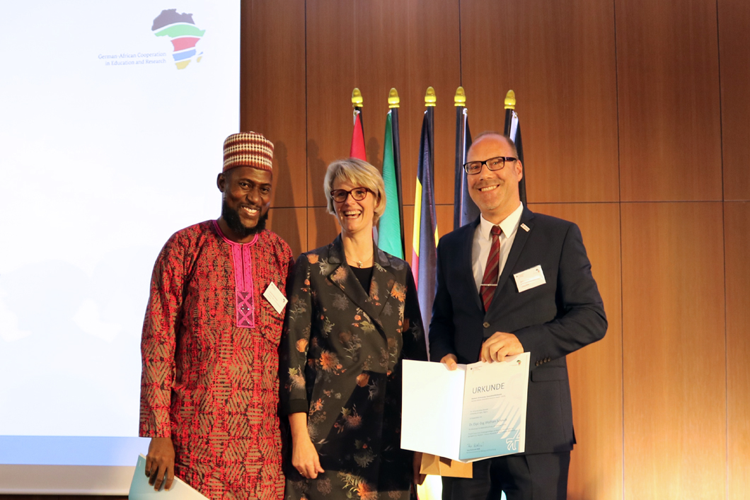 Dr. Kolawole Adisa Olonade, Bundesministerin für Bildung und Forschung Anja Karlicek und Dr.-Ing. Wolfram Schmidt, BAM Dr. Kolawole Adisa Olonade, Bundesministerin für Bildung und Forschung Anja Karlicek und Dr.-Ing. Wolfram Schmidt, BAM