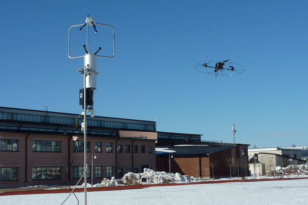 Mikro-UAS und stationäres 3D Ultraschall Anemometer während der Validierung des in-situ Messverfahrens zur Bestimmung des lokalen Windvektors im Freifeld. Mikro-UAS und stationäres 3D Ultraschall Anemometer während der Validierung des in-situ Messverfahrens zur Bestimmung des lokalen Windvektors im Freifeld.