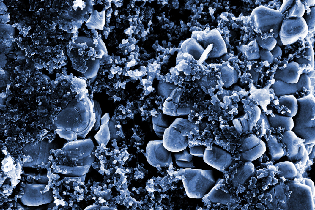 Rasterelektronenmikroskopische Aufnahme der positiven Elektrode einer Lithium-Ionen-Zelle. Die kleineren Nanopartikel aus Kohlenstoff sollen die Leitfähigkeit verbessern. Rasterelektronenmikroskopische Aufnahme der positiven Elektrode einer Lithium-Ionen-Zelle. Die kleineren Nanopartikel aus Kohlenstoff sollen die Leitfähigkeit verbessern.