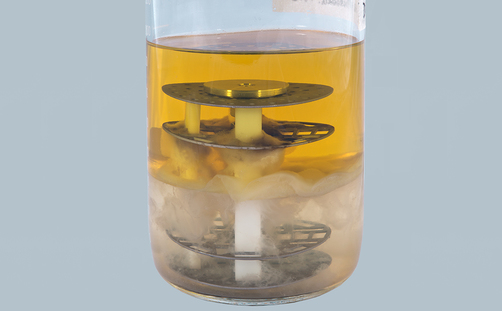 Laborglas mit Wasser, Mikroben und Diesel Laborglas mit Wasser, Mikroben und Diesel