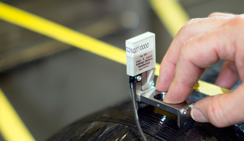 Ein BAM Mitarbeiter bringt einen Sensor auf einem Composite-Druckbehälter an. Ein BAM Mitarbeiter bringt einen Sensor auf einem Composite-Druckbehälter an.