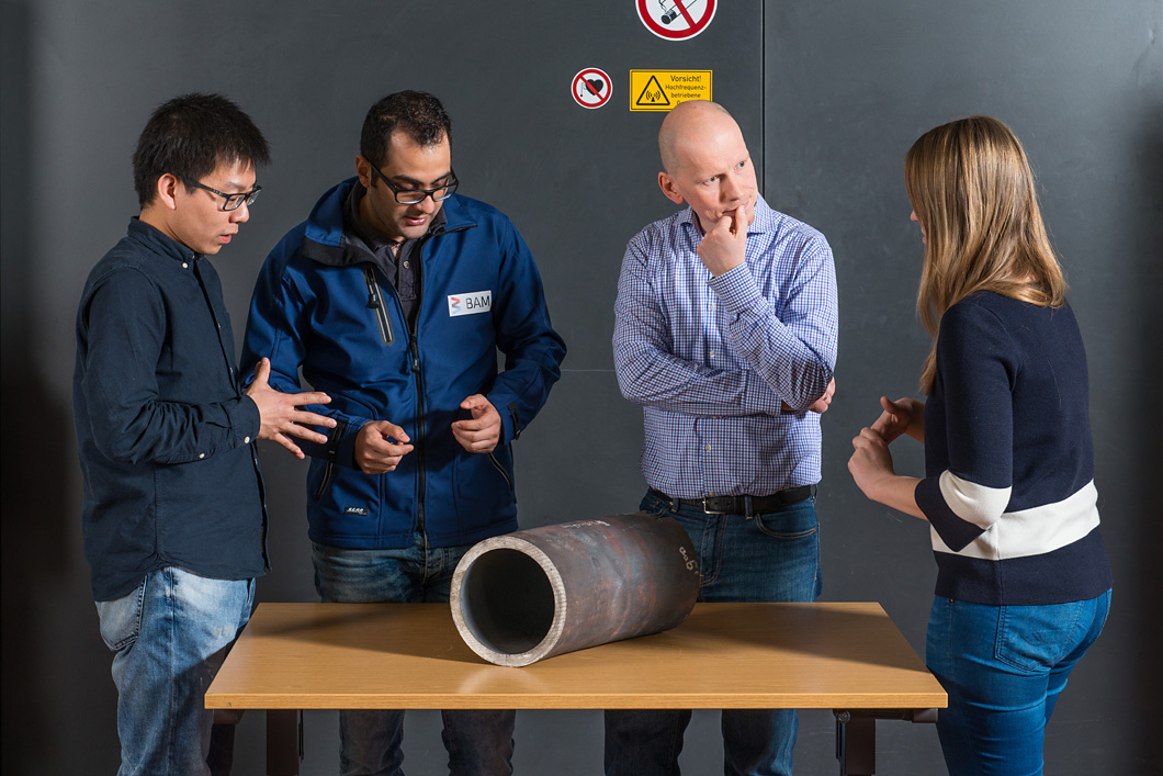 Das Team um Dr.-Ing. Jürgen Olbricht begutachtet ein angeliefertes Stück einer Kraftwerks-Dampfleitung (v.l.n.r.: Dong Wang, Dr.-Ing. Hamed Ravash, Dr.-Ing. Jürgen Olbricht und Maria Jürgens).