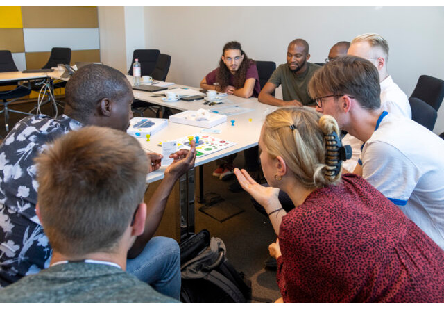 People are sitting around a conference table discussing a topic.