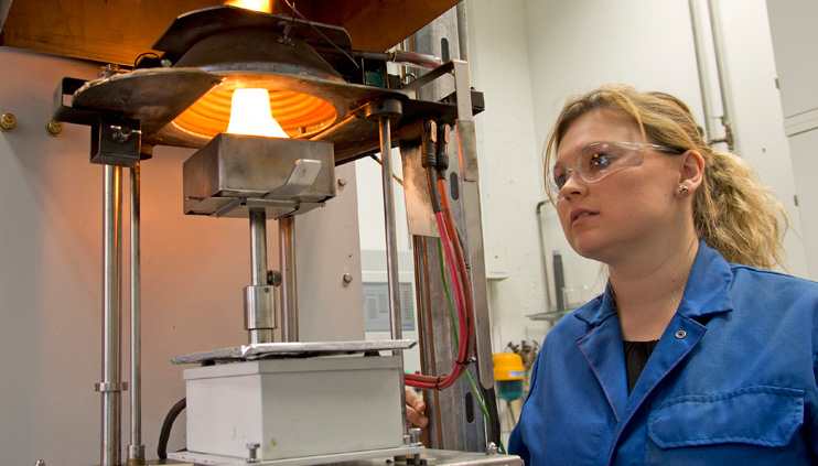 A BAM employee conducting a fire test in the laboratory A BAM employee conducting a fire test in the laboratory