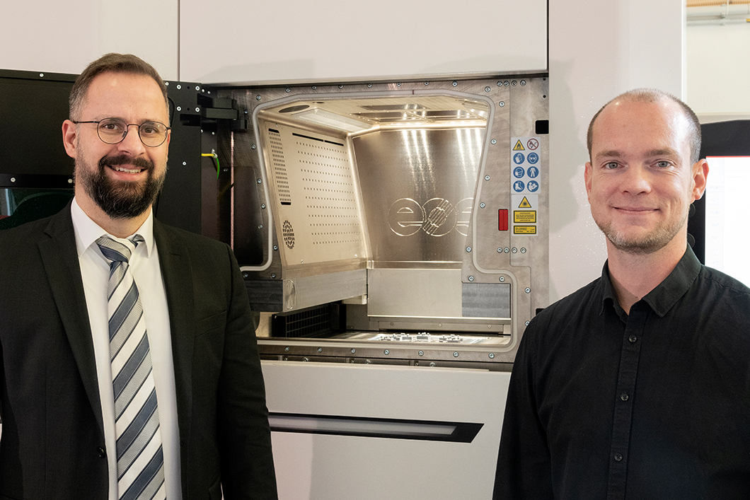 AM Anlagenpark Dr. Kai Hilgenberg, Leiter des BAM-Kompetenzzentrums Additive Fertigung und Dr. Martin Epperlein, Koordinator des Pilotprojekts vor der neuen 3D-Druckanlage für Metalle (v.l.n.r.).