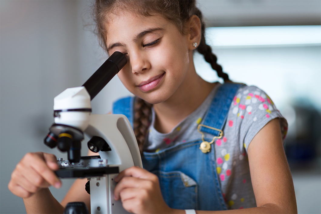 Stockbild Mädchen Wissenschaft Mädchen schaut durch ein Mikroskop