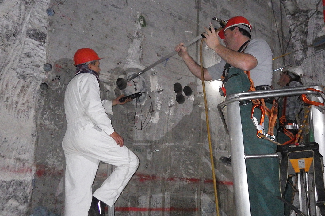 Messungen mit einer Ultraschall-Bohrlochsonde an einem Versuchsbauwerk in Morsleben (ERAM, BGE) Zwei Ingenieure mit Ultraschall-Bohrlochsonde an einem Versuchsbauwerk in Morsleben