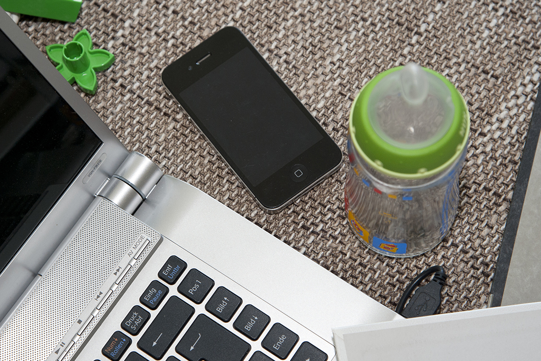 Laptop, Smartphone und Babyflasche