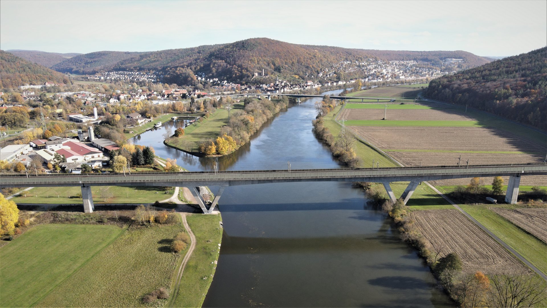 Paper des Monats 05/2023: TF Infrastruktur Das Foto zeigt eine Eisenbahnbrücke aus Beton, die einen Fluß quert.